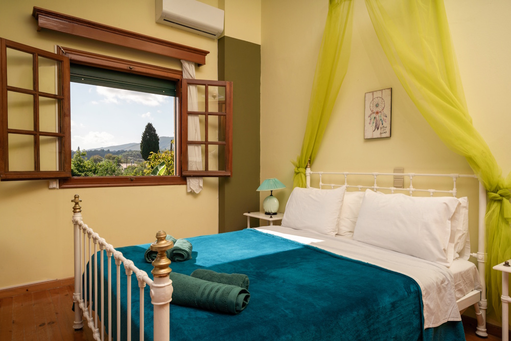 Bedroom with window view and double bed at Selini Villa in Kalithea