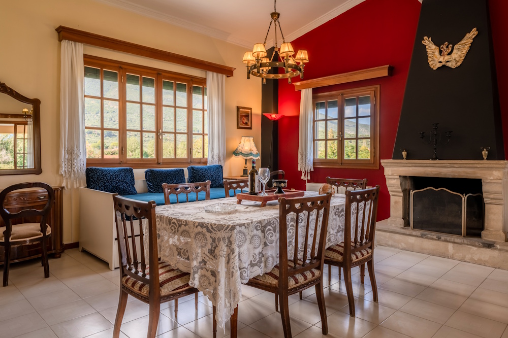 Dining room with fireplace and large windows at Selini Villa in Kalithea
