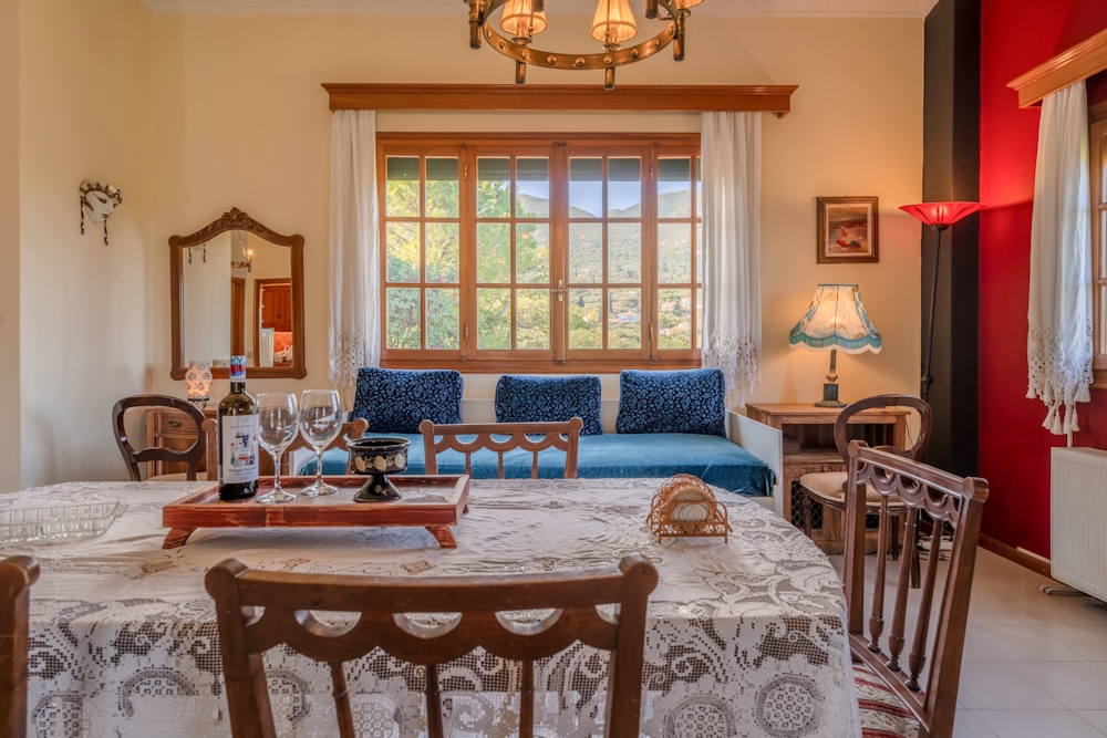 Dining area with seating and large window at Selini Villa in Kalithea