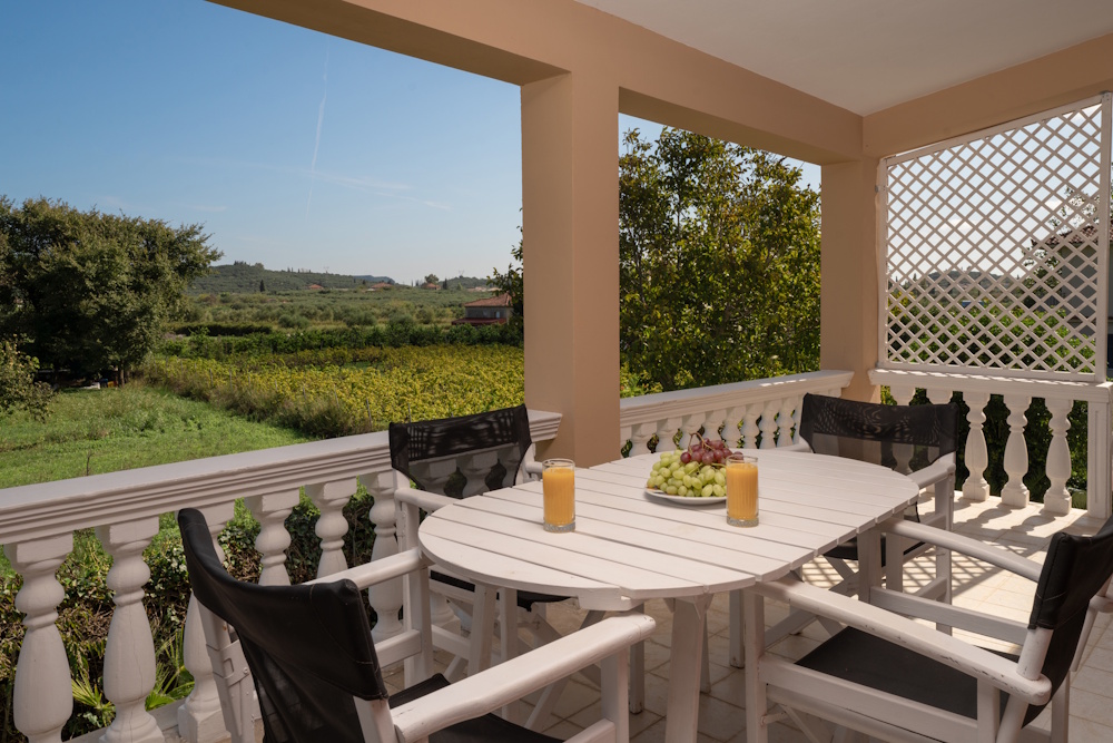 Balcony dining area with countryside view at Selini Villa in Kalithea