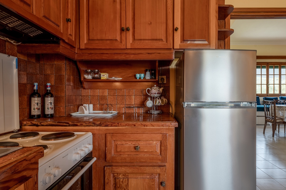 Fully equipped kitchen with wooden cabinets at Selini Villa in Kalithea